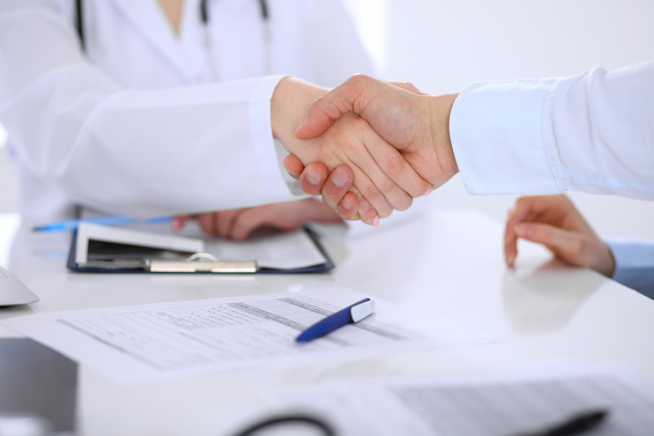 Doctor and patient handshaking. Hands close-up